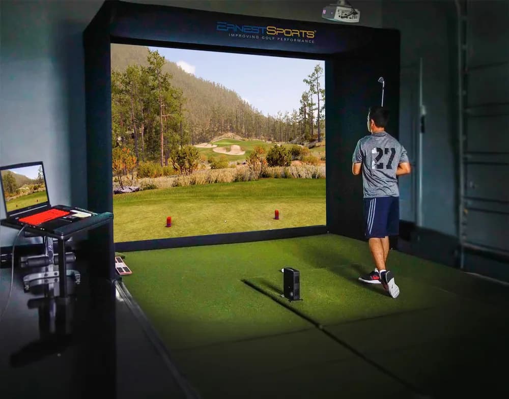 Golfer hitting into a Tour Plus 2.0 simulator bay running GSPro