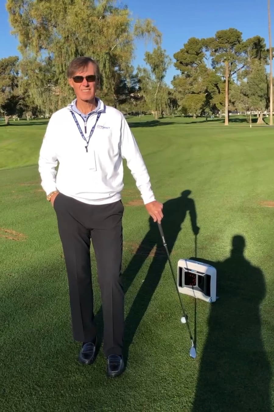 Joe Ernest, founder and CEO of Ernest Sports, on the course with a club and an Ernest Sports launch monitor